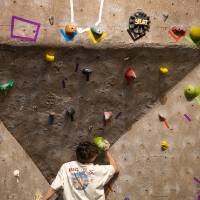 competitor makes a strenuous press into a ball-shaped hold to get above the cave